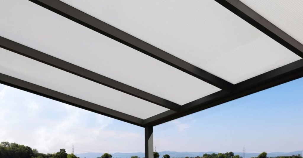 Gros plan d'une toiture de carport en aluminium et panneaux transparents. 