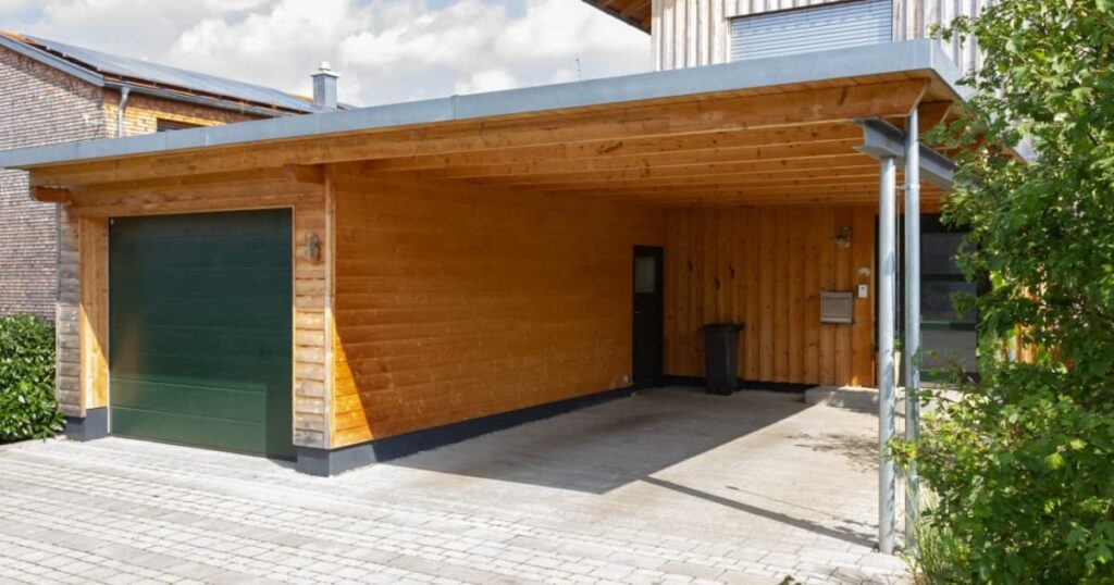Carport en bois construit dans la continuité d'un garage. 